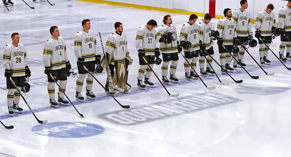 Jogadores da Lindenwood University posicionados no gelo para a execução do hino nacional. Reprodução/ Lindenwood University Athletics