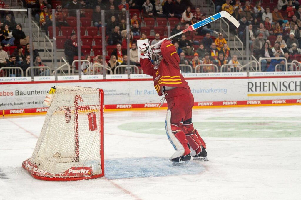 Goleiro do Düsseldorfer EG desconta a frustração batendo o stick no travessão