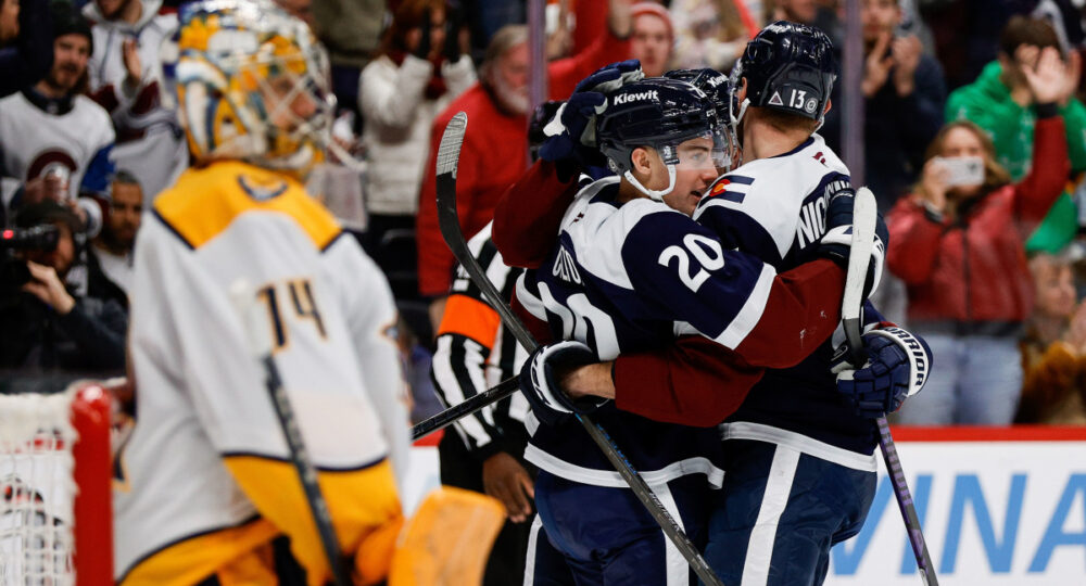 Juuse Saros observa jogadores do Colorado Avalanche comemorando após um gol