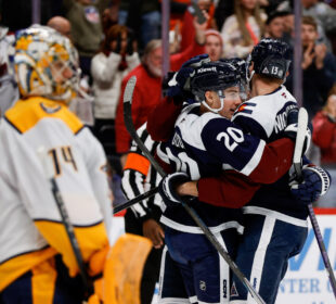 Juuse Saros observa jogadores do Colorado Avalanche comemorando após um gol
